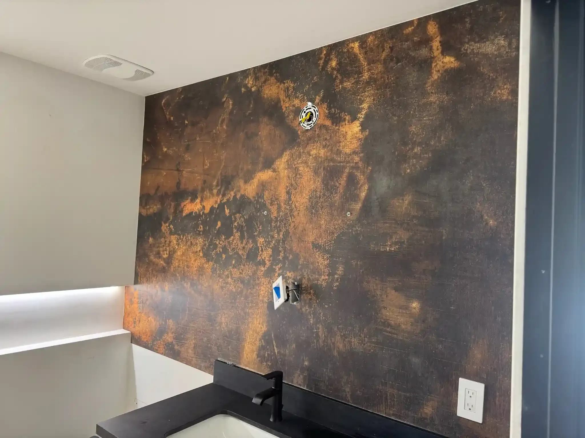 A richly textured dark wallcovering in a small room