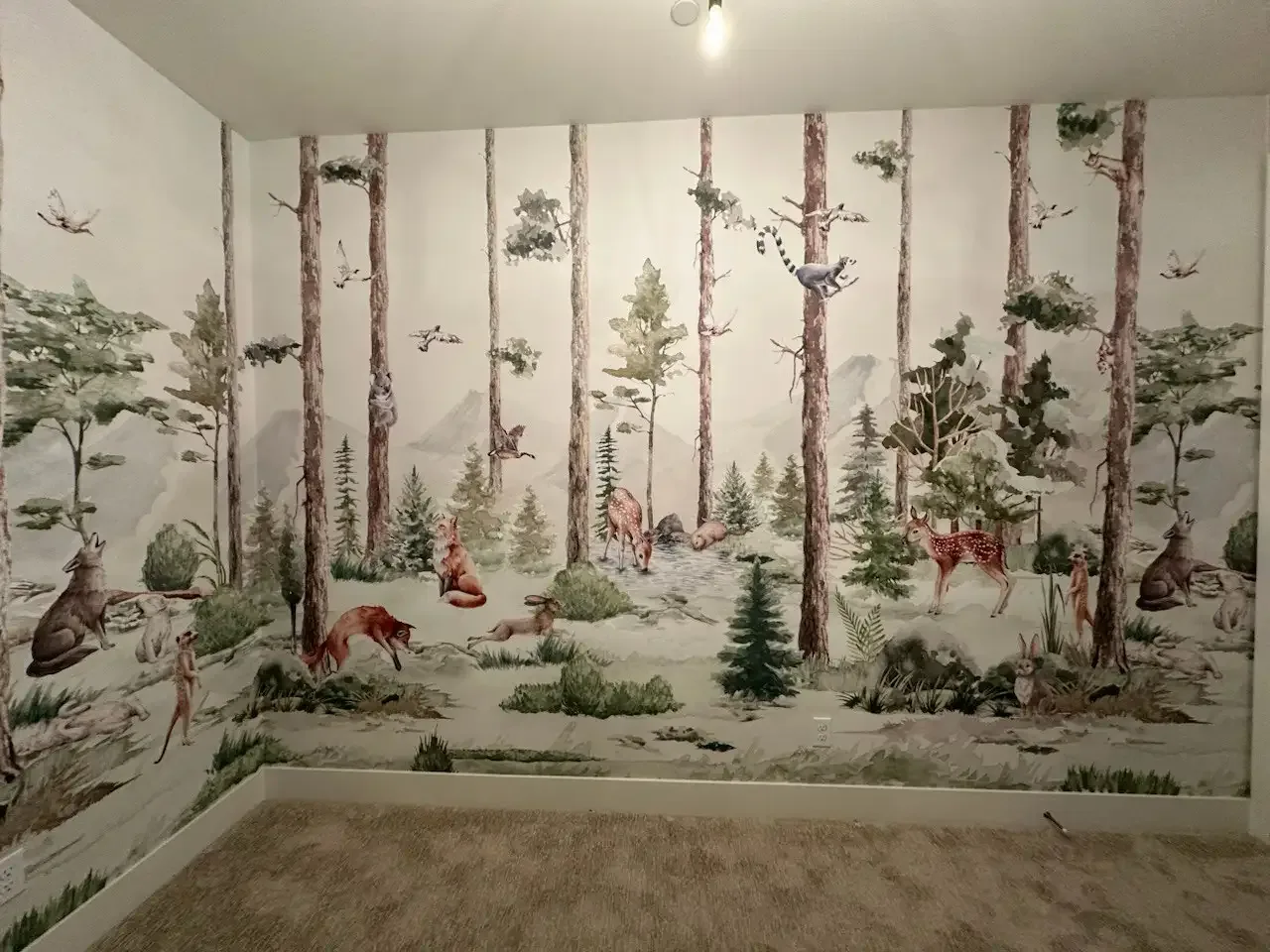 A woodland mural with a continuous scenic pattern across two walls